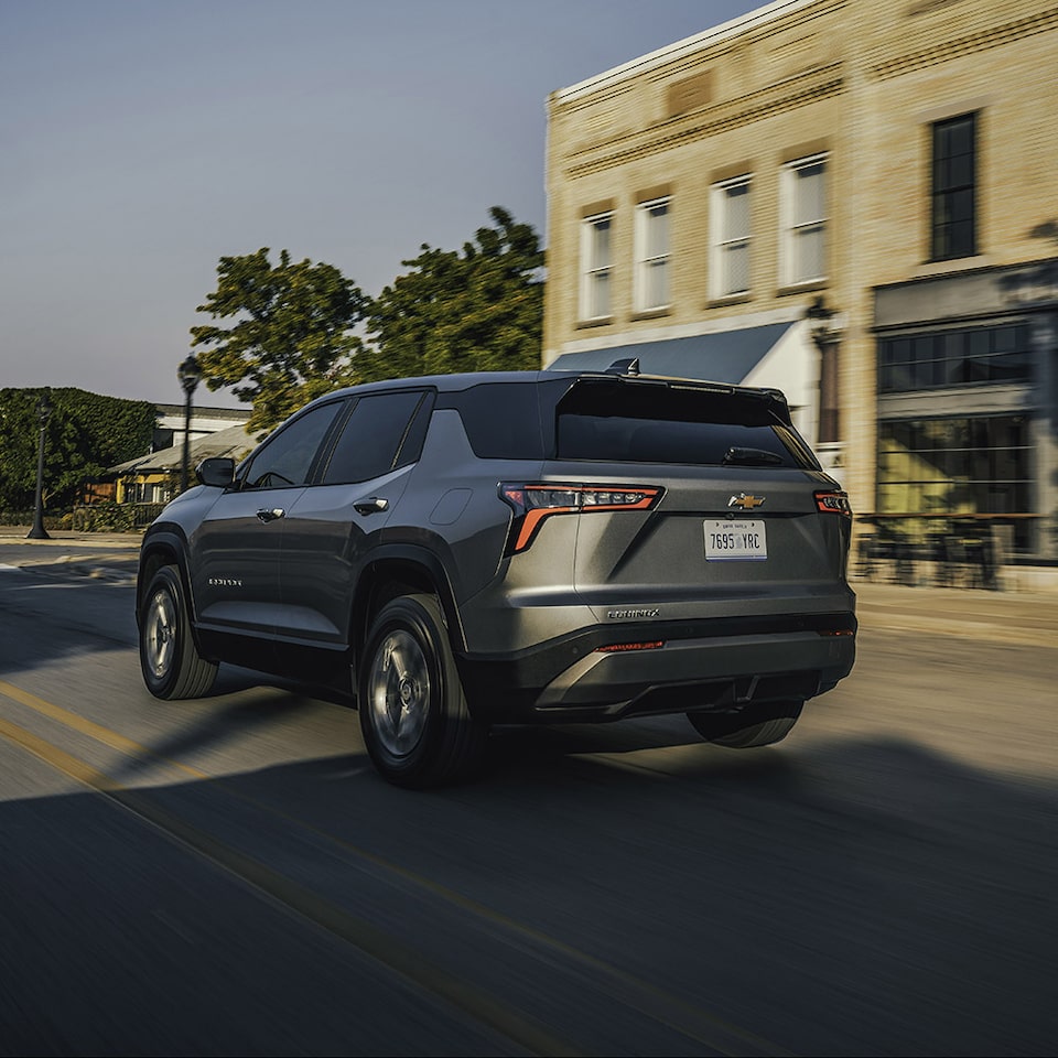  Back-side view of the 2026 Chevrolet Equinox driving in the city.