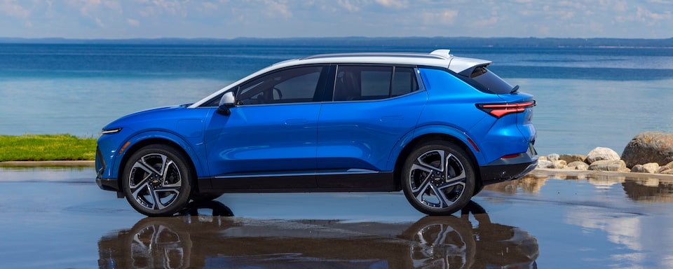 Vue latérale du Chevrolet Equinox EV 2025 stationné à la plage.