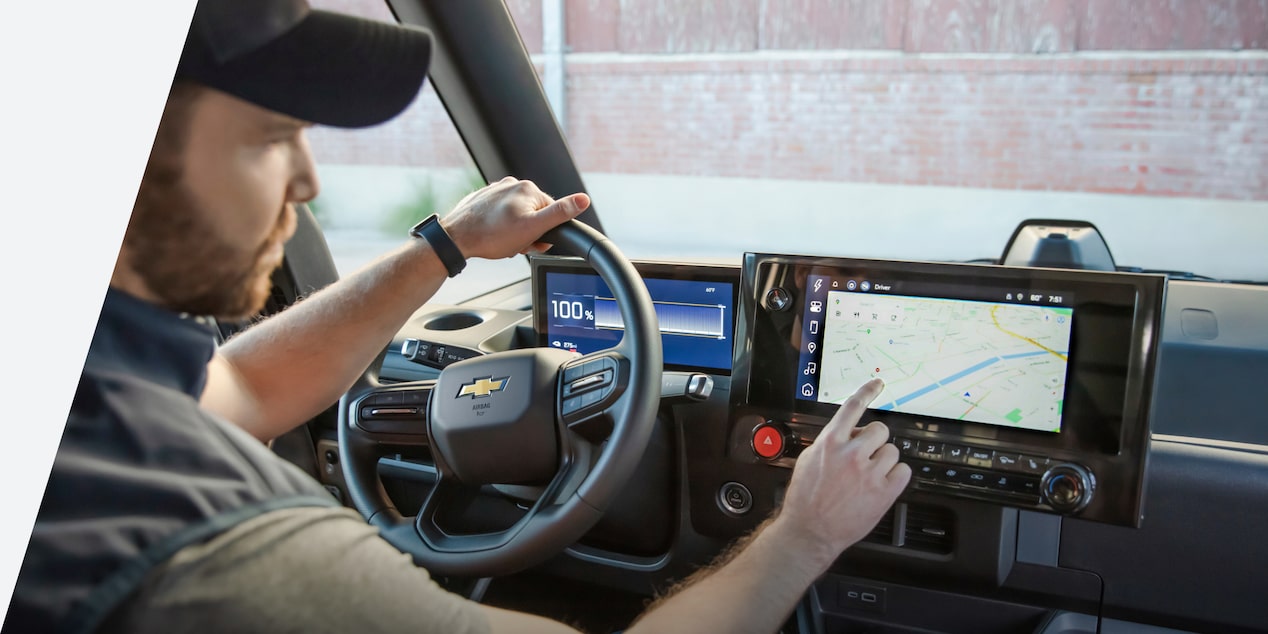 Un conducteur touche l’écran du système d’infodivertissement de la fourgonnette électrique Chevrolet BrightDrop 2025.