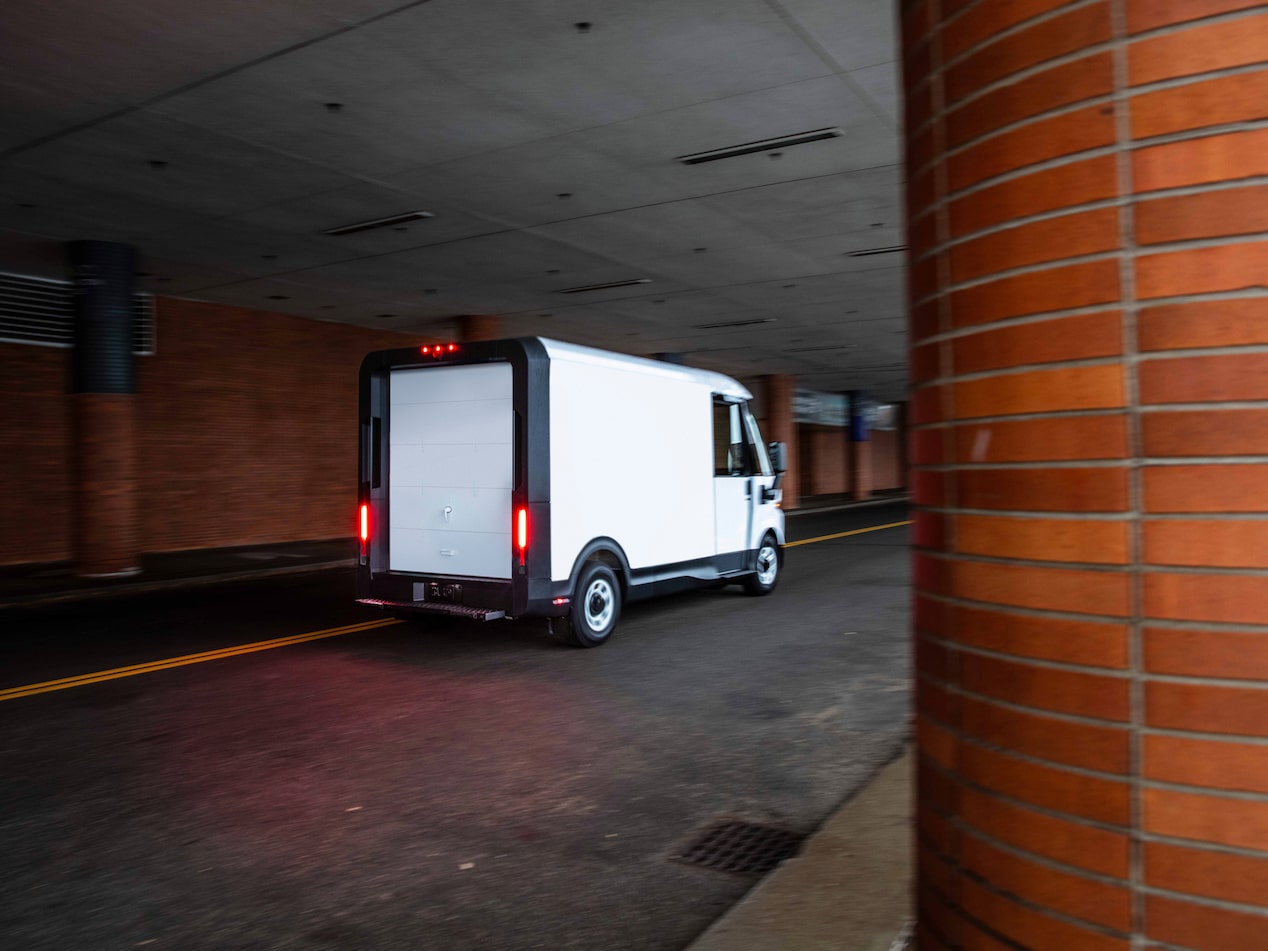 Vue latérale arrière de la fourgonnette électrique Chevrolet BrightDrop 2025 en mouvement dans un tunnel.