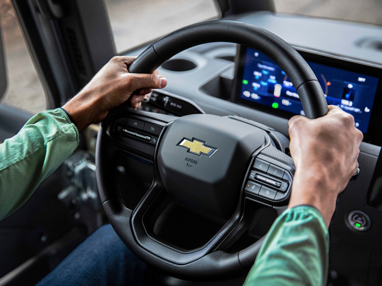 Vue rapprochée de mains sur le volant de la fourgonnette électrique Chevrolet BrightDrop 2025.