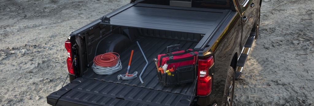 Tools and equipment stowed on the tonneau-covered trunk bed of a GM Fleet vehicle.