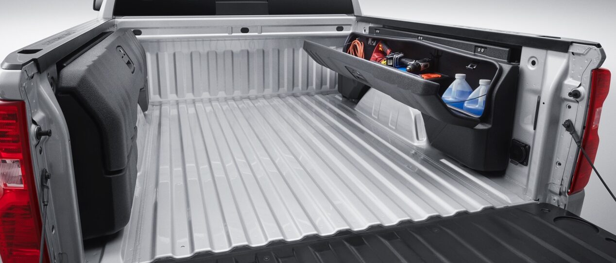 An open trunk bed with equipment and accessories stowed on a GM Fleet vehicle.