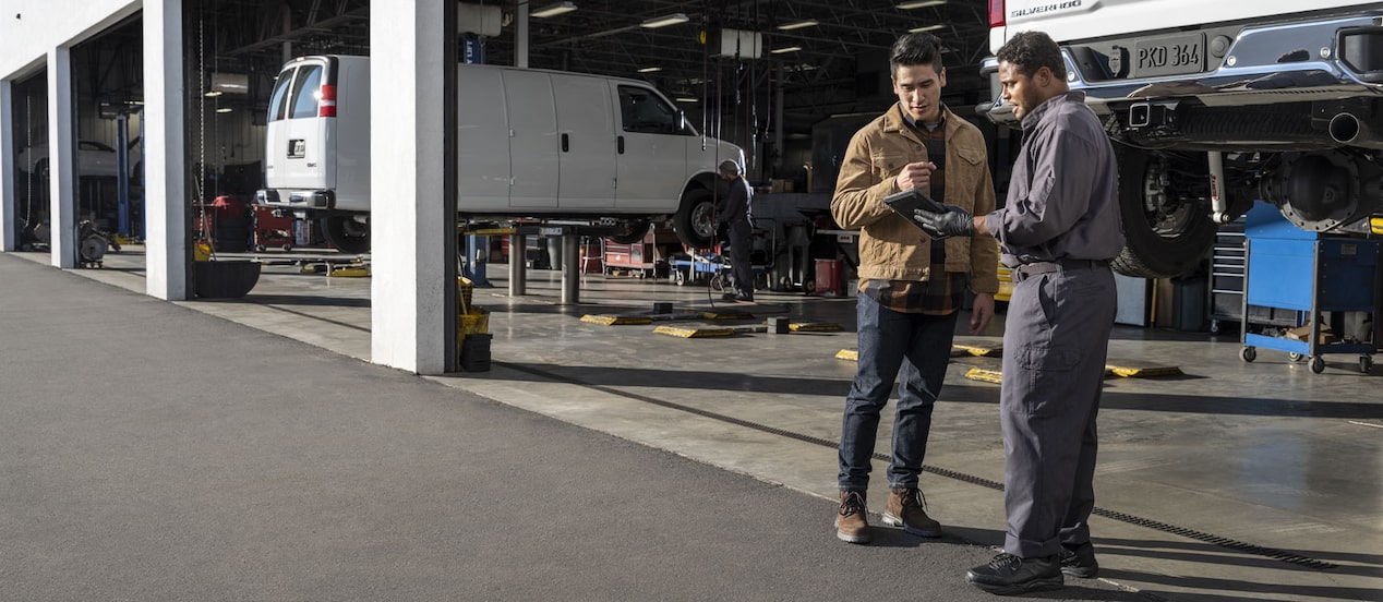 A GM auto mechanic assisting a customer.