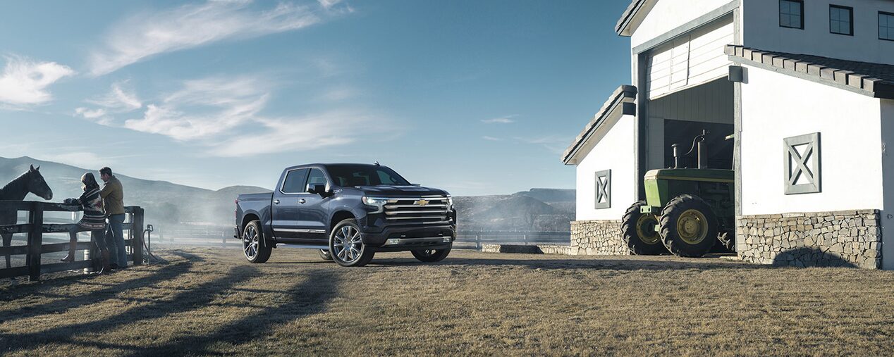Une travailleuse de la construction dépose une boîte à outils dans la caisse du Chevrolet Silverado 1500 2024.