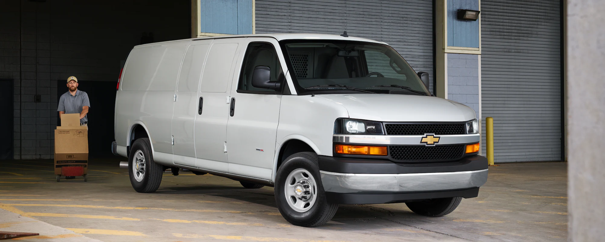 2024 GM Envolve Chevrolet Express Cargo Van parked outside a warehouse.