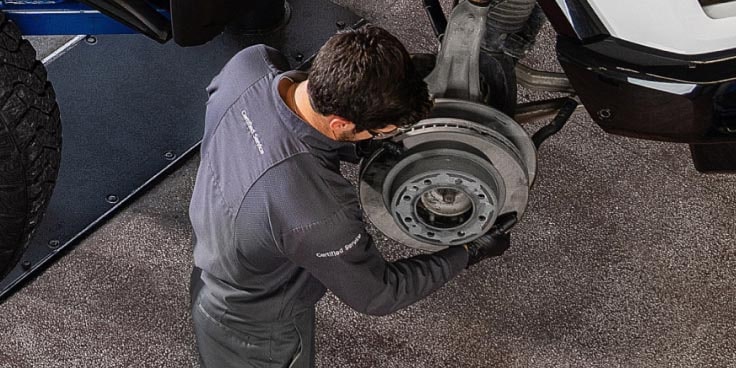 A Car Mechanic replacing the wheels of a GM Envolve vehicle.