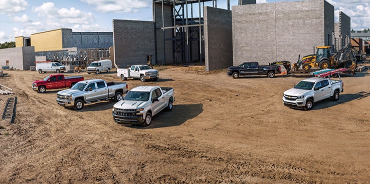 Multiple GM vehicles parked at a construction site.