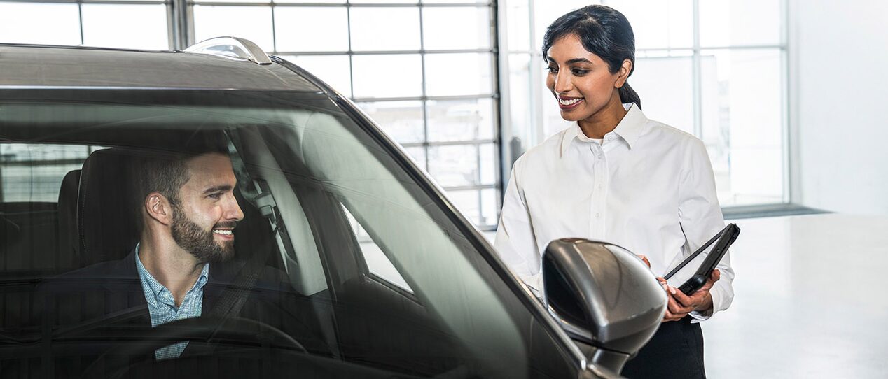 GM Fleet agent showing the interiors of a GM vehicle to a customer.