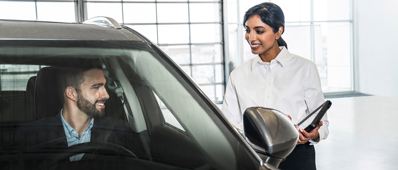 GM Fleet agent showing the interiors of a GM vehicle to a customer.
