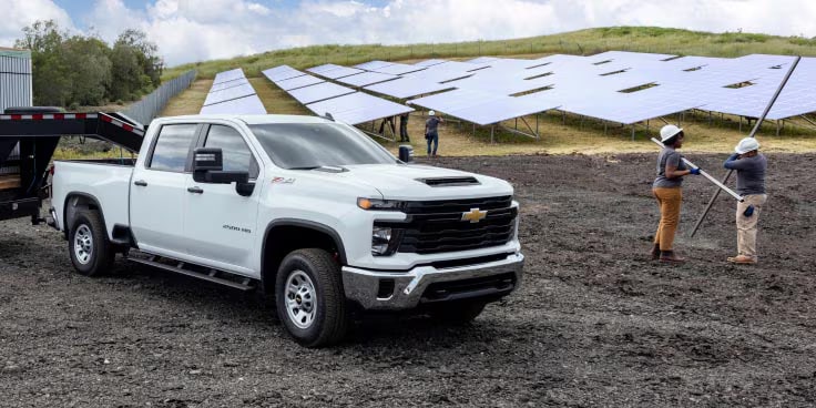 A GM commercial truck parked near solar panels.