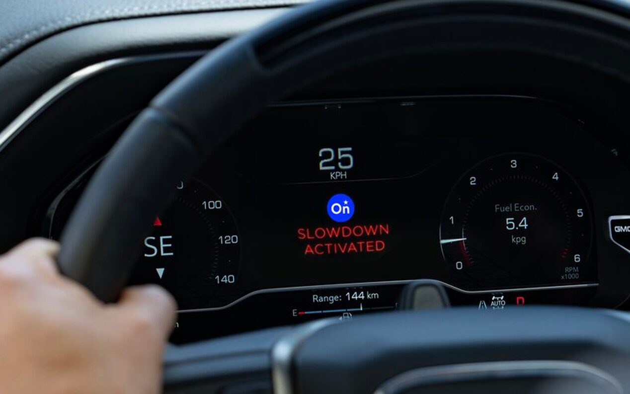 Close-up of OnStar "Slow Down" Feature Activated on a Vehicle's Digital Dashboard 