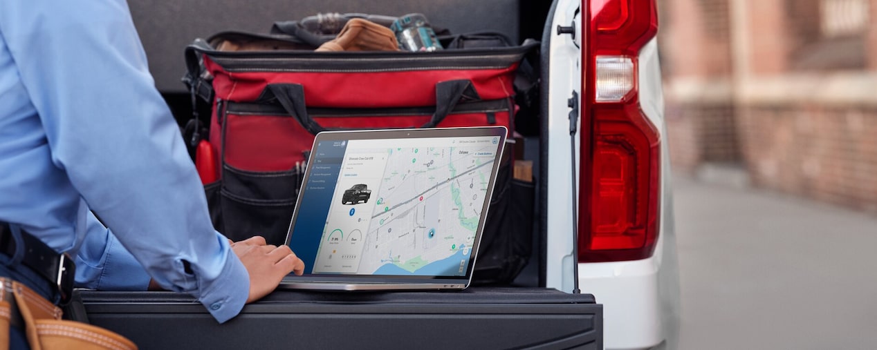 A person accessing real-time info on a GM Envolve vehicle from a laptop.