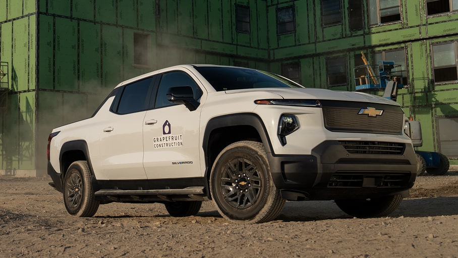 A white Chevrolet Silverado EV parked on a jobsite.