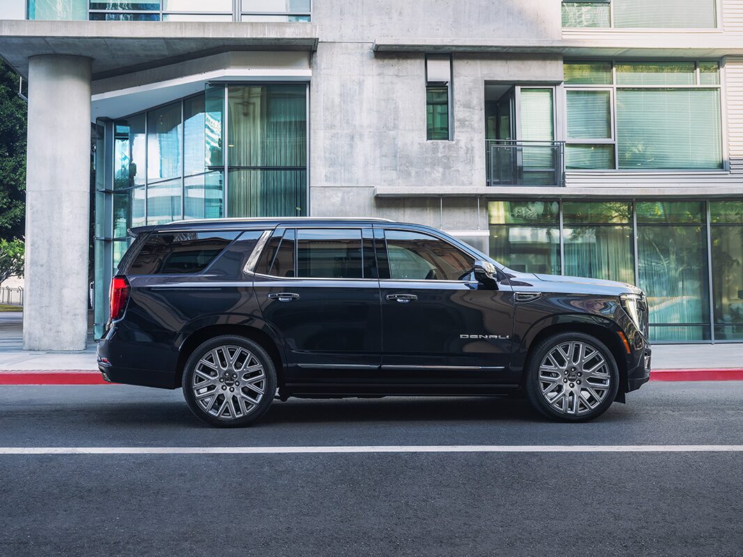 A right-side view of a 2026 GMC Yukon parked in front of a building
