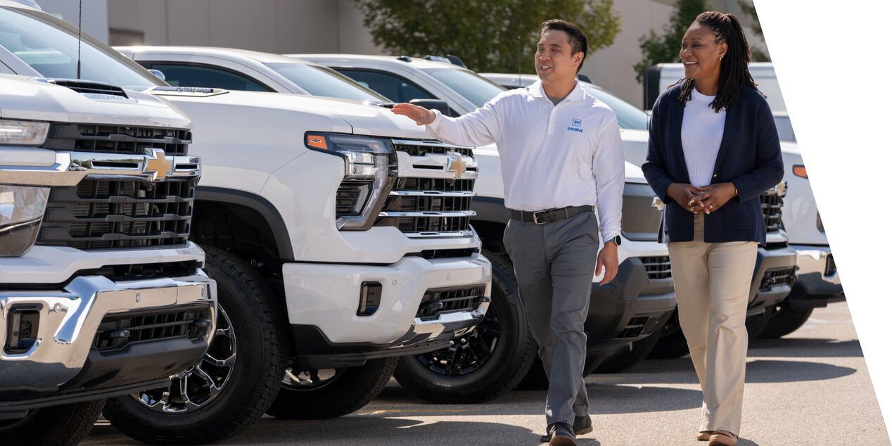 A GM Envolve sales associate showing a lineup of Chevrolet Silverados to a customer