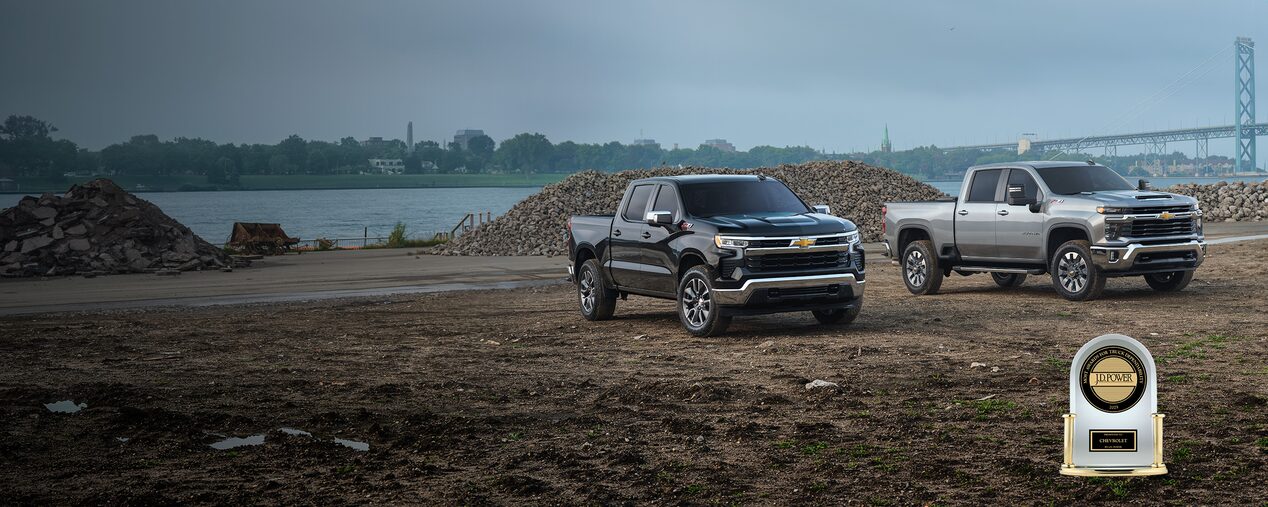 Two Chevrolet Silverados parked on a jobsite