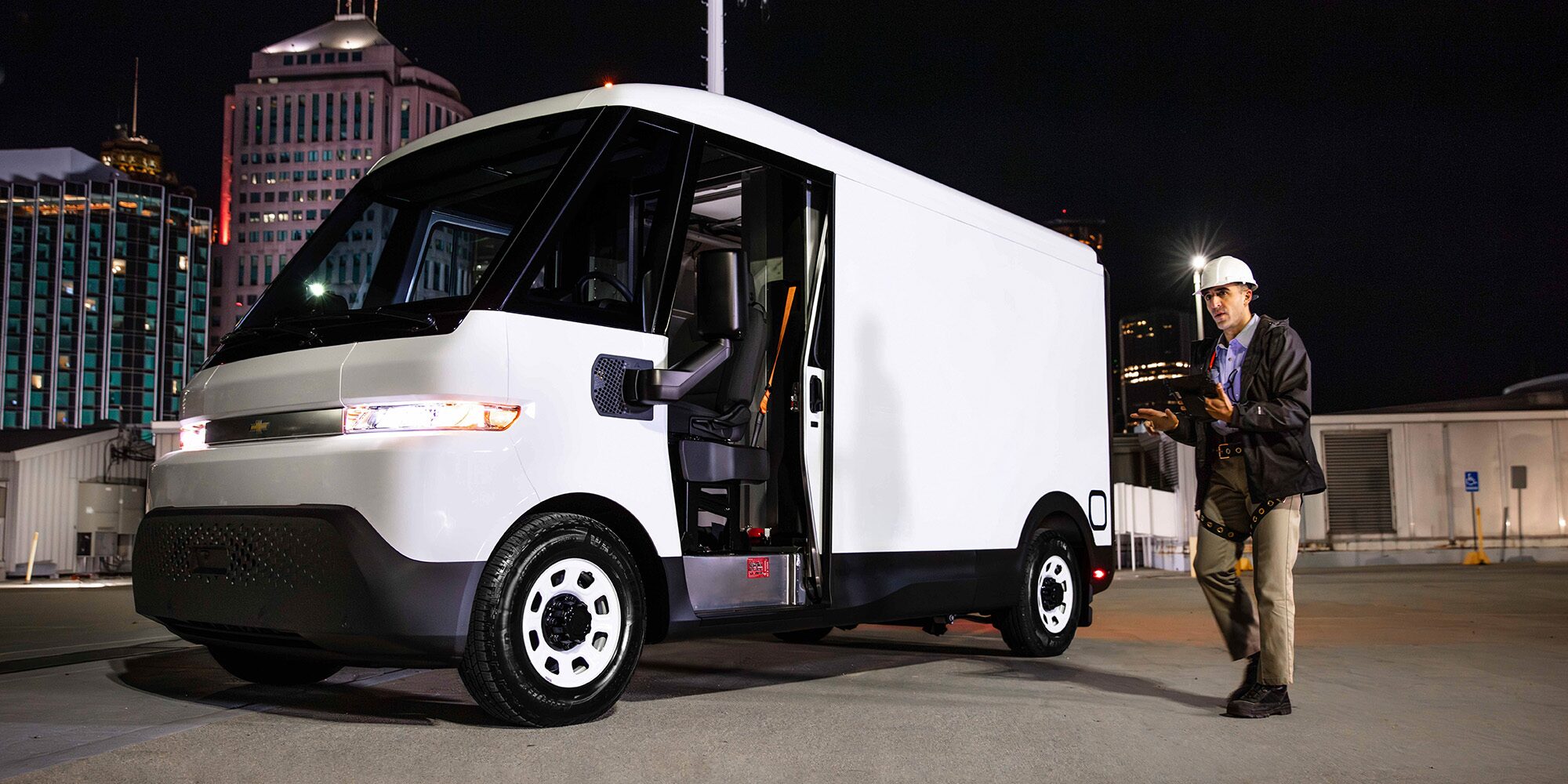 A white Chevrolet BrightDrop parked on a job site at night.