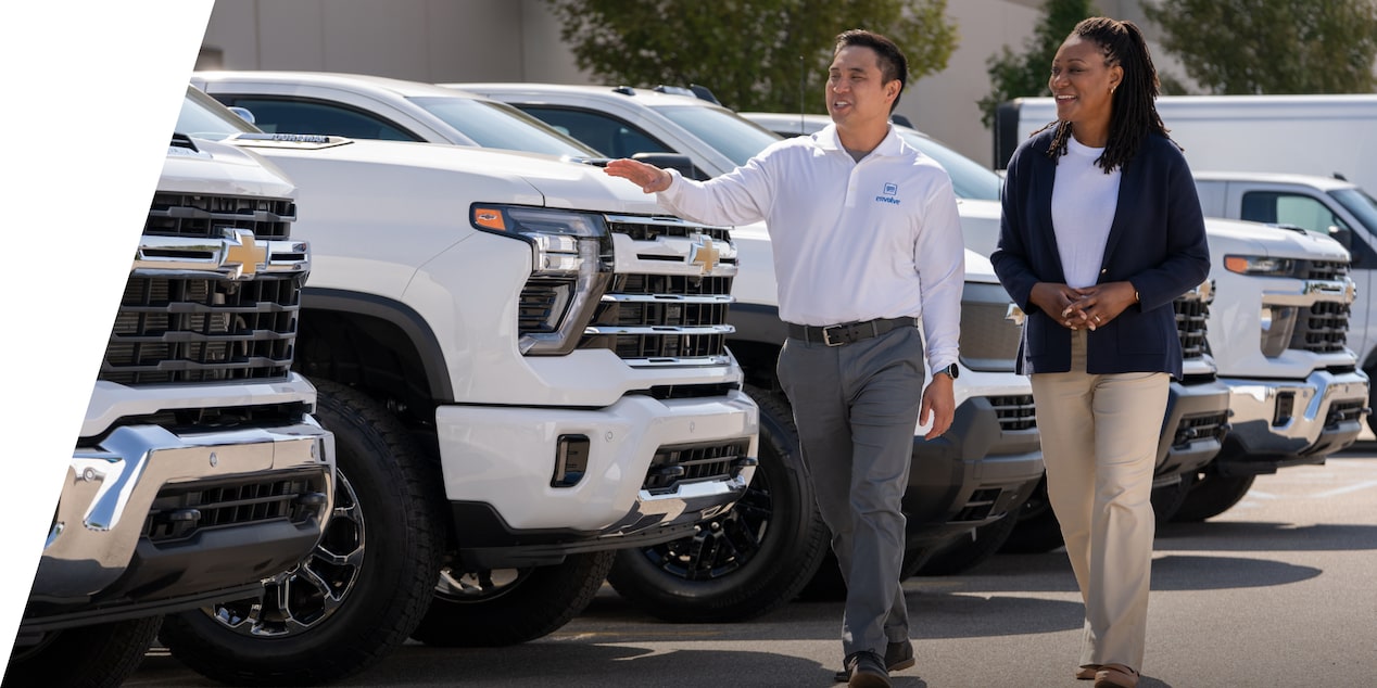 A GM Envolve sales associate showing a lineup of Chevrolet Silverados to a customer