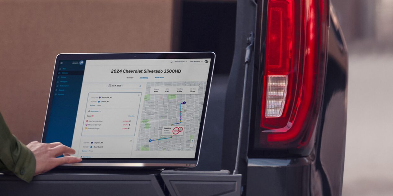 Someone accessing OnStar One Fleet from their laptop on their truck's tailgate