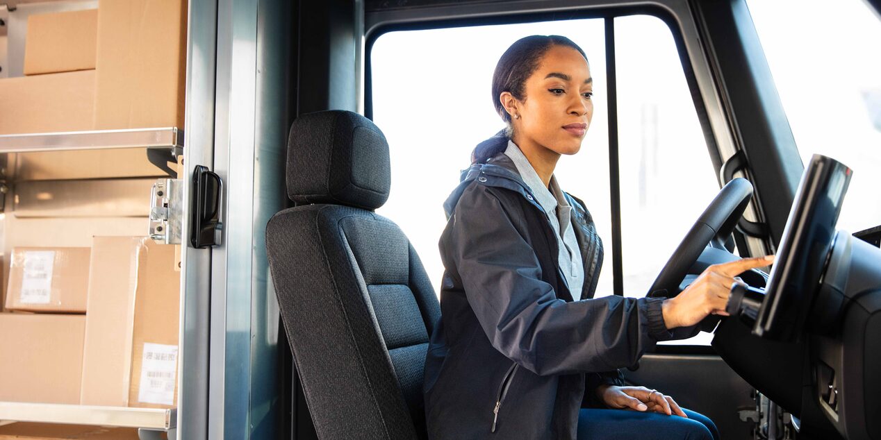 A driver using the touchscreen on a Chevrolet BrightDrop