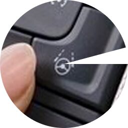 Close-up of a driver pressing the Super Cruise hands-free driving activation button.