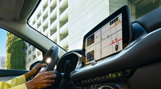 A person viewing Waze routes in the infotainment screen of an OnStar-subscribed GM vehicle.