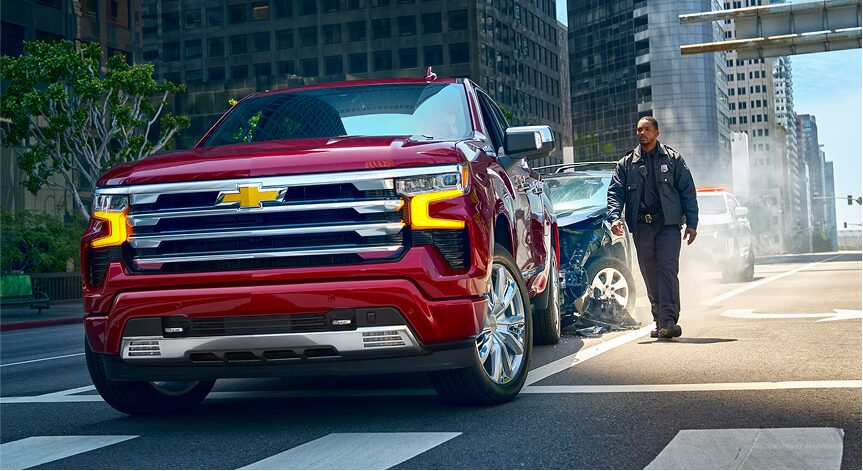 Police officer walking towards a car crashed on the side of the road