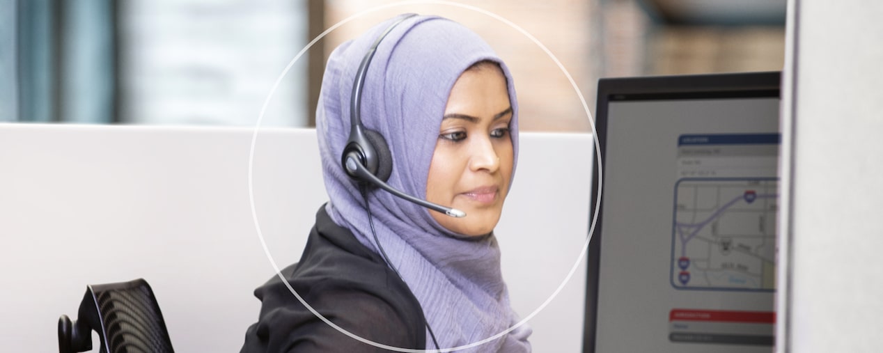 Female OnStar Advisor Wearing Headset Sitting at Desk 