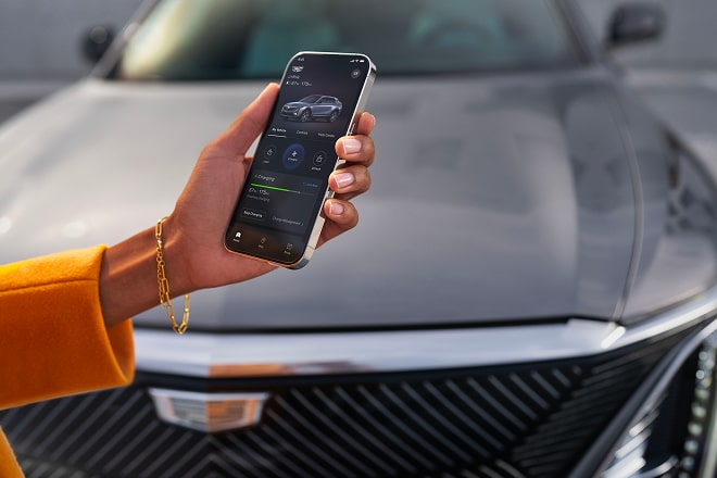User Checking Their Phone at the Front End of a Cadillac 